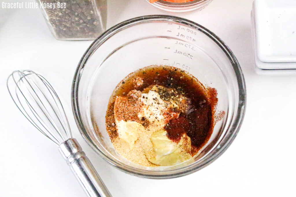 Ingredients for mayo dressing on clear mixing bowl.